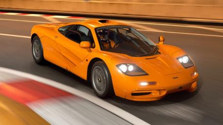 Sleek Orange Supercar on a Dynamic Track wallpaper