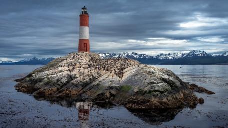 Lighthouse Oasis Amidst Rugged Nature wallpaper