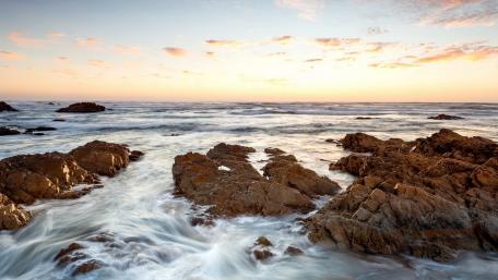 Serene Seaside Sunset Over Rocky Shoreline wallpaper