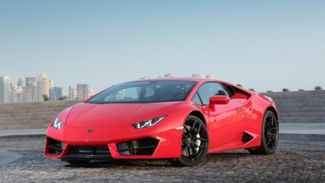 Sleek Red Supercar on Urban Backdrop wallpaper