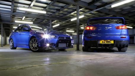 Stylish Blue Mitsubishi Cars in Industrial Setting wallpaper