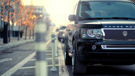 Sleek Black Range Rover Against Urban Backdrop wallpaper
