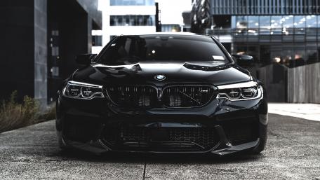 Sleek Black BMW in Urban Setting wallpaper