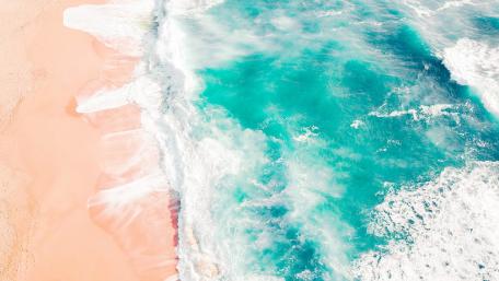 Serene Ocean Waves Meeting Soft Sandy Shoreline wallpaper