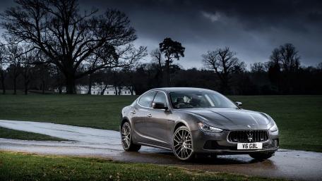 Sleek Luxury Car Against a Dramatic Sky wallpaper