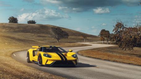 Dynamic Yellow Supercar on Scenic Roadway wallpaper