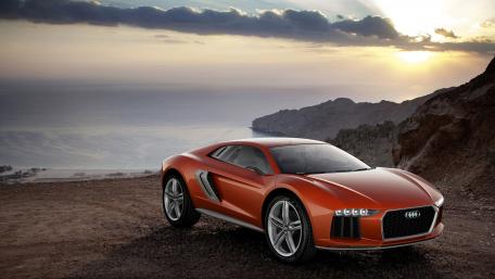 Sleek Orange Audi Against a Stunning Sunset View wallpaper