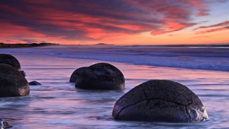 Serene Sunset Over Oceanic Boulders wallpaper