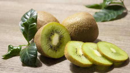 Fresh and Vibrant Kiwi on Wooden Surface wallpaper