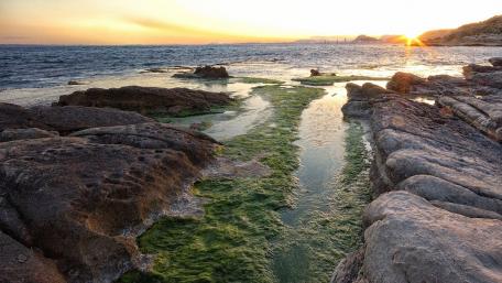 Serene Sunset Over Coastal Rocks and Waterway wallpaper
