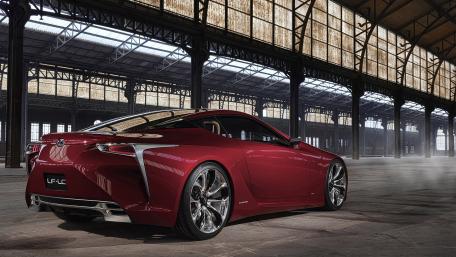 Sleek Red Luxury Car in Industrial Setting wallpaper