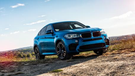 Sleek Blue BMW X6 on a Scenic Landscape wallpaper