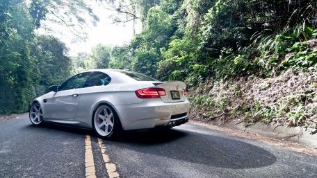 Sleek Silver Car on a Peaceful Forest Road wallpaper