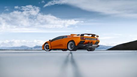 Dynamic Orange Supercar in Majestic Landscape wallpaper