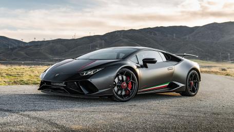 Sleek Black Lamborghini on Scenic Roadway wallpaper