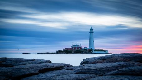 Majestic Lighthouse Amidst Serene Waters wallpaper