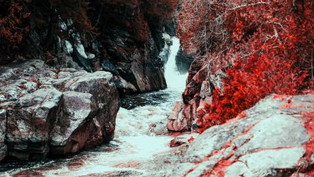 Vibrant River Flowing Through Scenic Rocks wallpaper