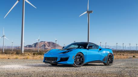 Dynamic Blue Sports Car Against Wind Turbines Landscape wallpaper