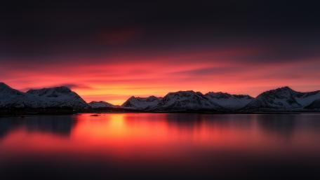Vibrant Sunset Over Majestic Mountains Reflecting in Water wallpaper