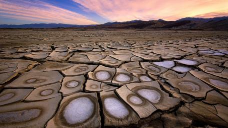 Cracked Earth Beneath a Colorful Sunrise wallpaper