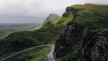 Majestic Highland Road Amidst Lush Greenery wallpaper