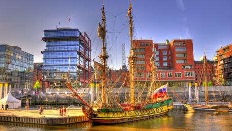 Vibrant Harbor Scene with Historic Ship and Modern Architecture wallpaper