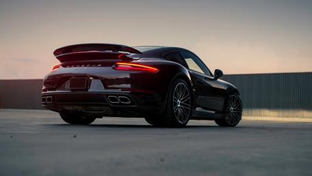 Sleek Black Sports Car in Sunset Glow wallpaper