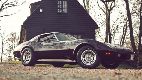 Classic Black Corvette in Nature's Embrace wallpaper