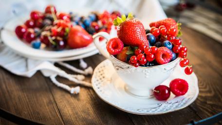Colorful Fruit Medley in Elegant Teacup wallpaper