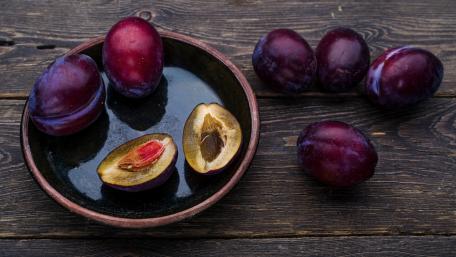 Plump Juicy Plums on a Rustic Tabletop wallpaper