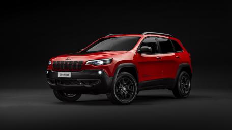 Sleek Red Jeep Cherokee on Black Background Featuring Modern Design Elements wallpaper