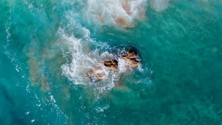 Tranquil Ocean Waves Embracing Rocks wallpaper