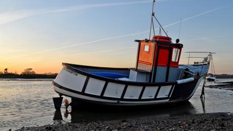 Serene Sunset Overtranquil Fishing Boat wallpaper