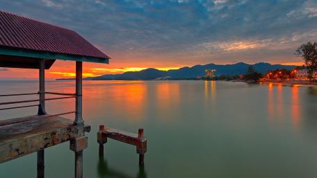 Serene Sunset Over Tranquil Waters and Mountains wallpaper