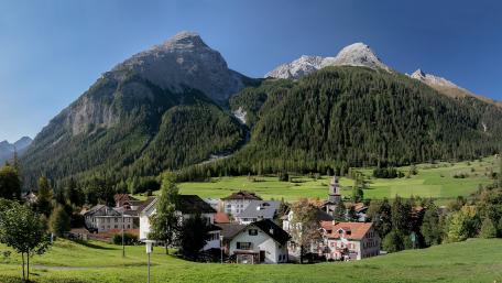 Majestic Mountains Embracing Serene Village wallpaper