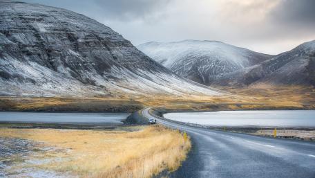 Serene Mountain Landscape with Winding Road and Lake View wallpaper