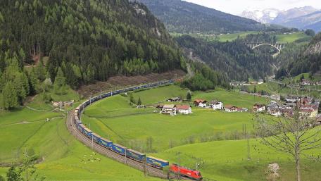 Scenic Train Journey Through Lush Green Valleys wallpaper