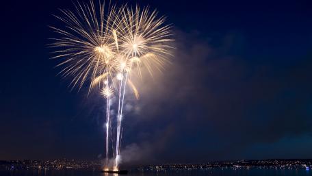 Breathtaking Nighttime Fireworks Display Over Waterway wallpaper