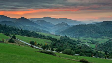 Serene Valley at Dusk Amidst Majestic Mountains wallpaper