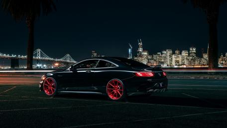Sleek Sportscar Against a Night City Skyline wallpaper