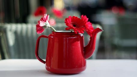 Vibrant Red Teapot with Flowers Displaying Cheerful Elegance wallpaper