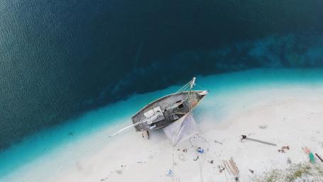 Serenity of the Shoreline and Abandoned Boat wallpaper