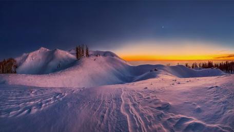Snowy Peaks Under a Vibrant Sunset Sky wallpaper