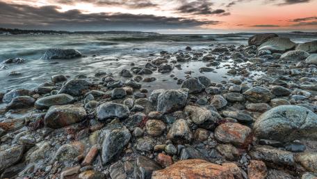 Stony Beach at Dusk with Waves Flowing Over Rocks wallpaper