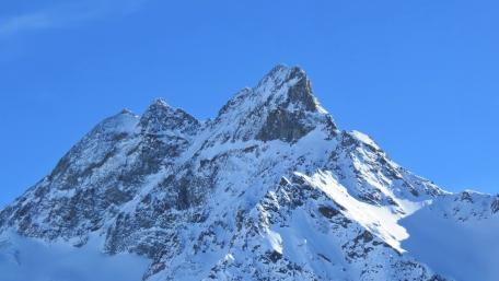 Majestic Snow-Capped Peaks Under Clear Blue Sky wallpaper