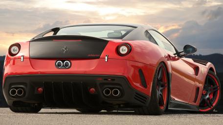 Sleek Red Ferrari in a Sunset Scene wallpaper
