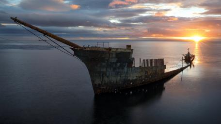 Forgotten Shipwreck Under a Serene Sunset wallpaper