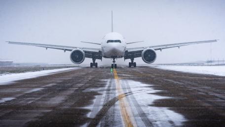 Majestic Aircraft Ready for Takeoff in Winter Snowfall wallpaper