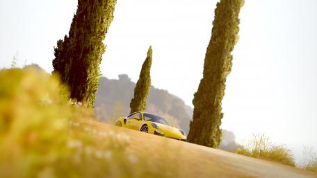 Vibrant Yellow Sports Car on Scenic Roadway wallpaper