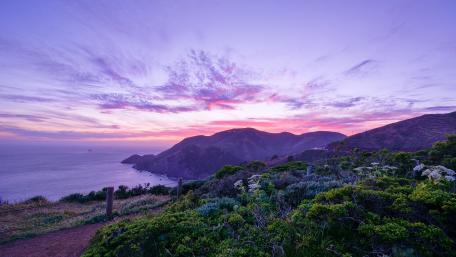 Serene Coastal Sunset Over Majestic Mountains wallpaper